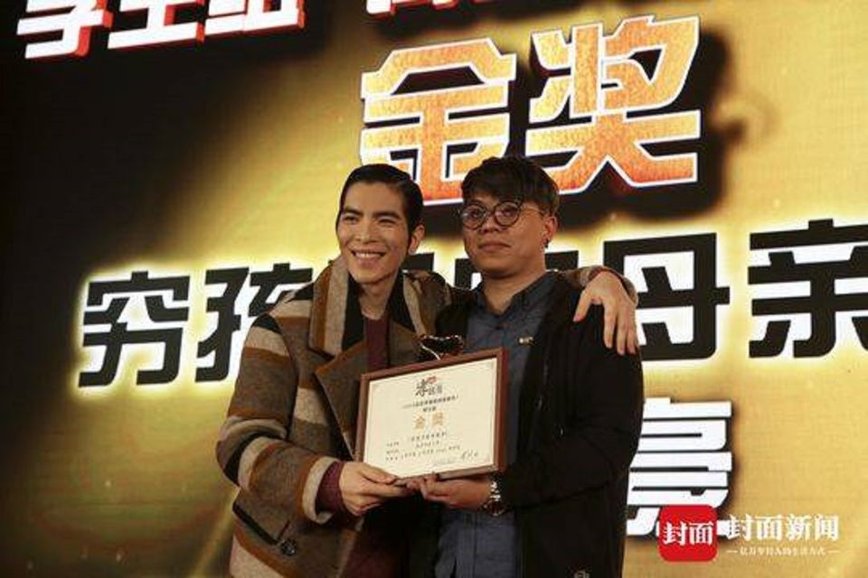蕭敬騰為學生組金獎《窮孩子的母親節》得主黃信豪頒獎。